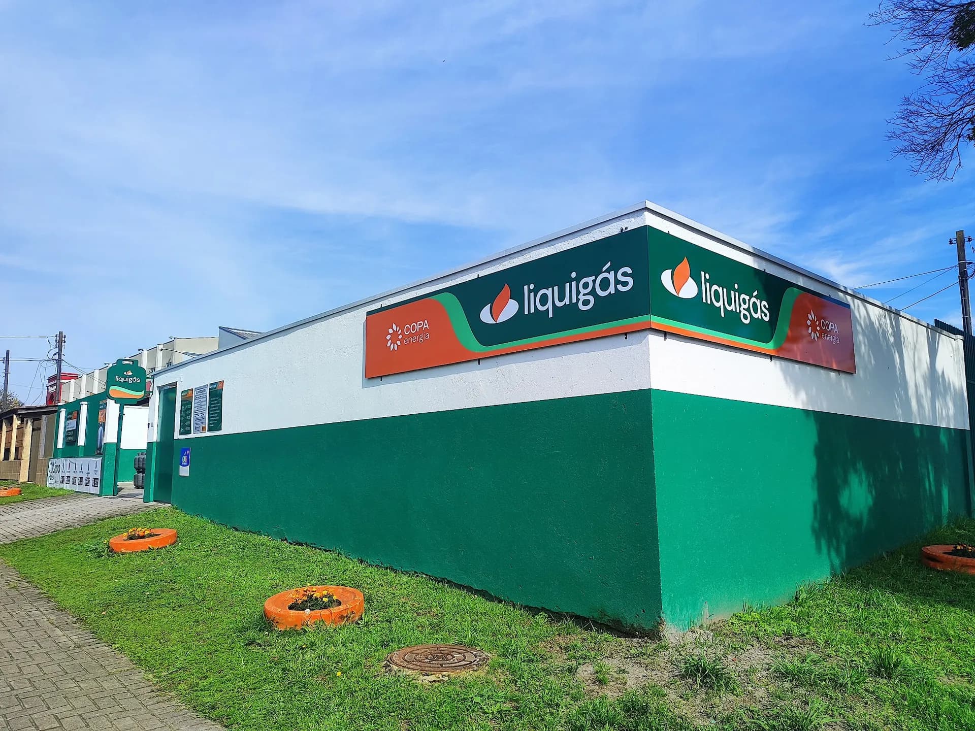Esquina da Lino Gás no Abranches, com o muro verde e branco, os painéis da Liquigás e o totem verde