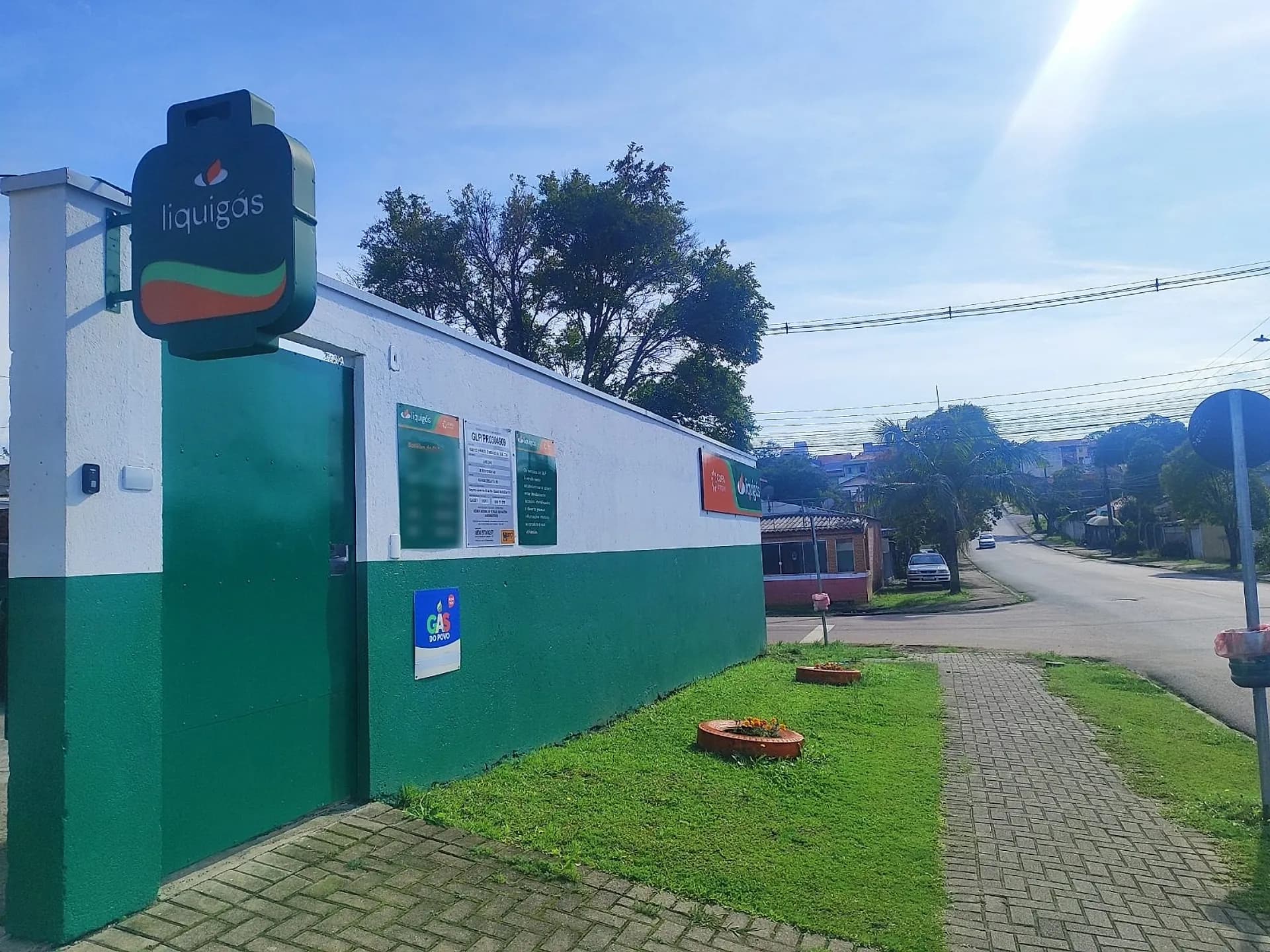 Fachada da Lino Gás no Abranches: totem verde em forma de botijão, muro verde e branco, portão e a placa Aqui tem Gás do Povo
